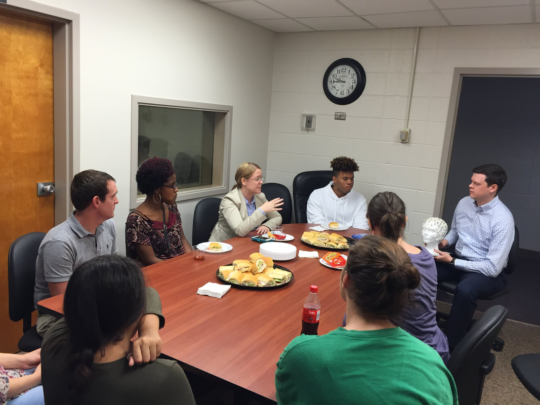 Members of Dr. Nora Charles' Youth Substance use and Risky Behavior Lab learning about EEG at a luncheon with other faculty